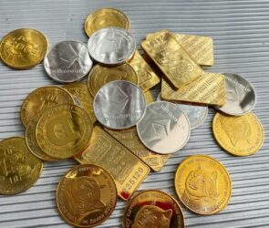 a pile of gold and silver coins sitting on top of a table