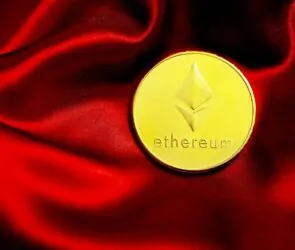 a close up of a red cloth with a gold coin